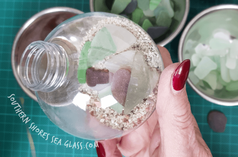 filling the christmas tree baubles with sand and sea glass
